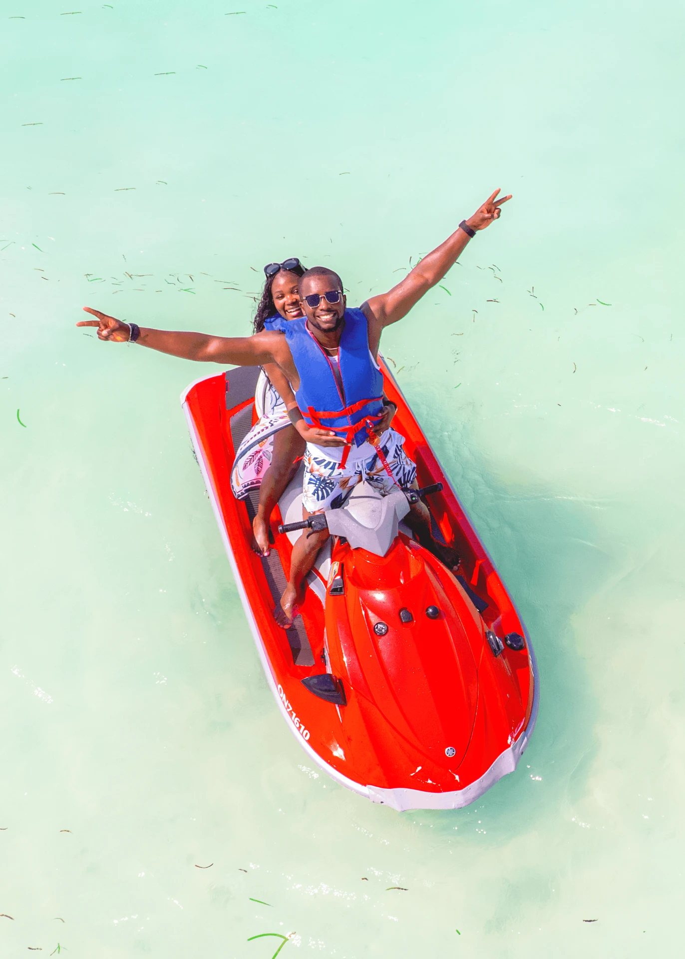 Jet ski in Paje, Zanzibar — aerial view of two riders celebrating on a red jet ski