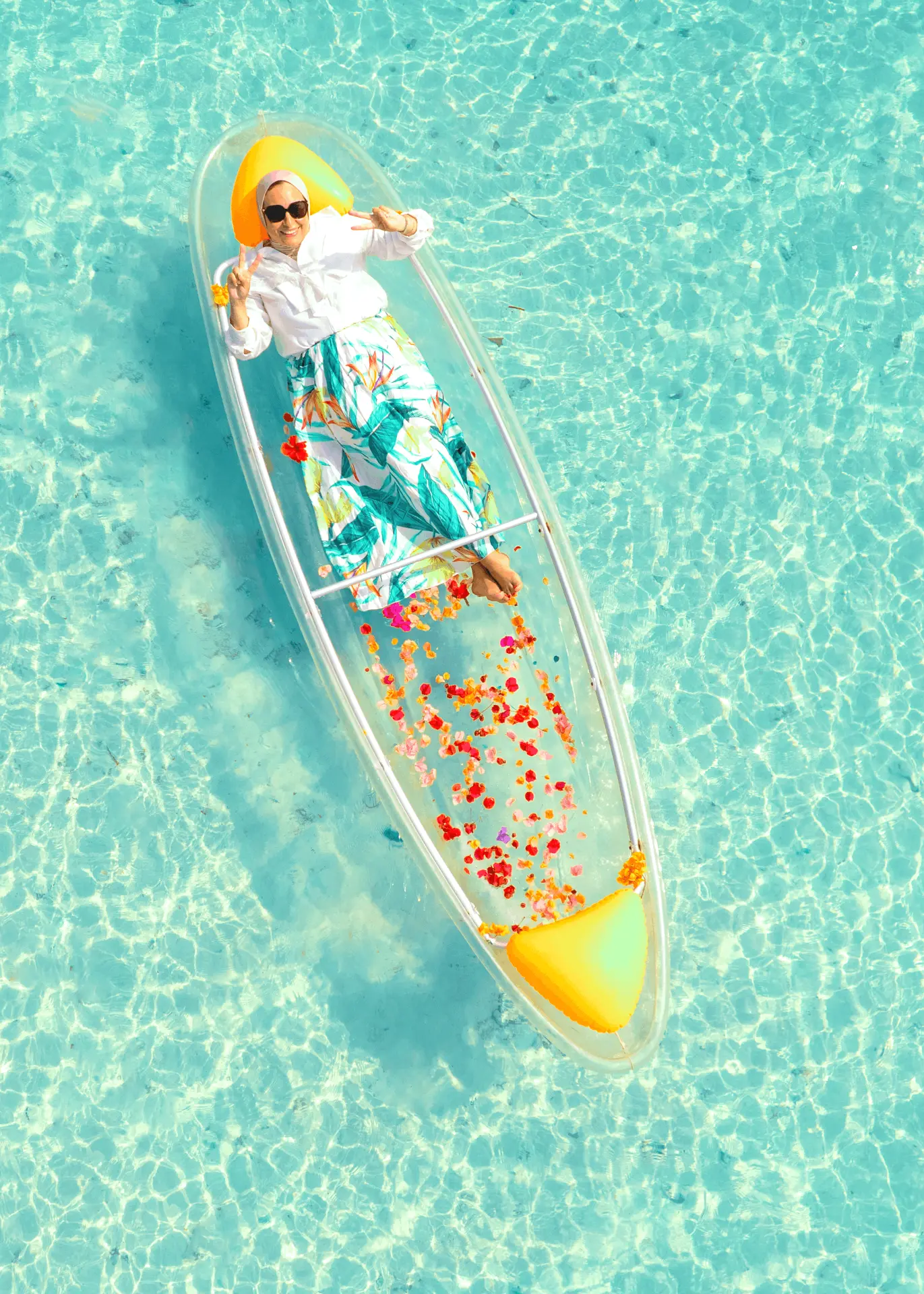 Transparent kayak and drone shoot in Paje, Zanzibar — aerial view of a guest lying in a flower-styled clear kayak