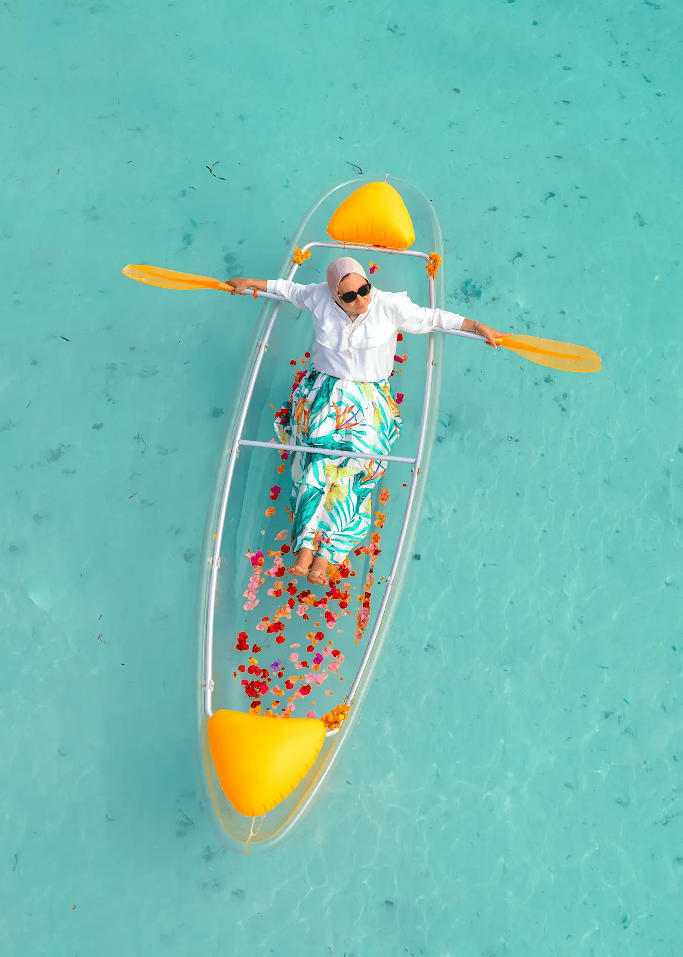Transparent kayak in Paje, Zanzibar — guest paddling a clear kayak decorated with petals on turquoise water